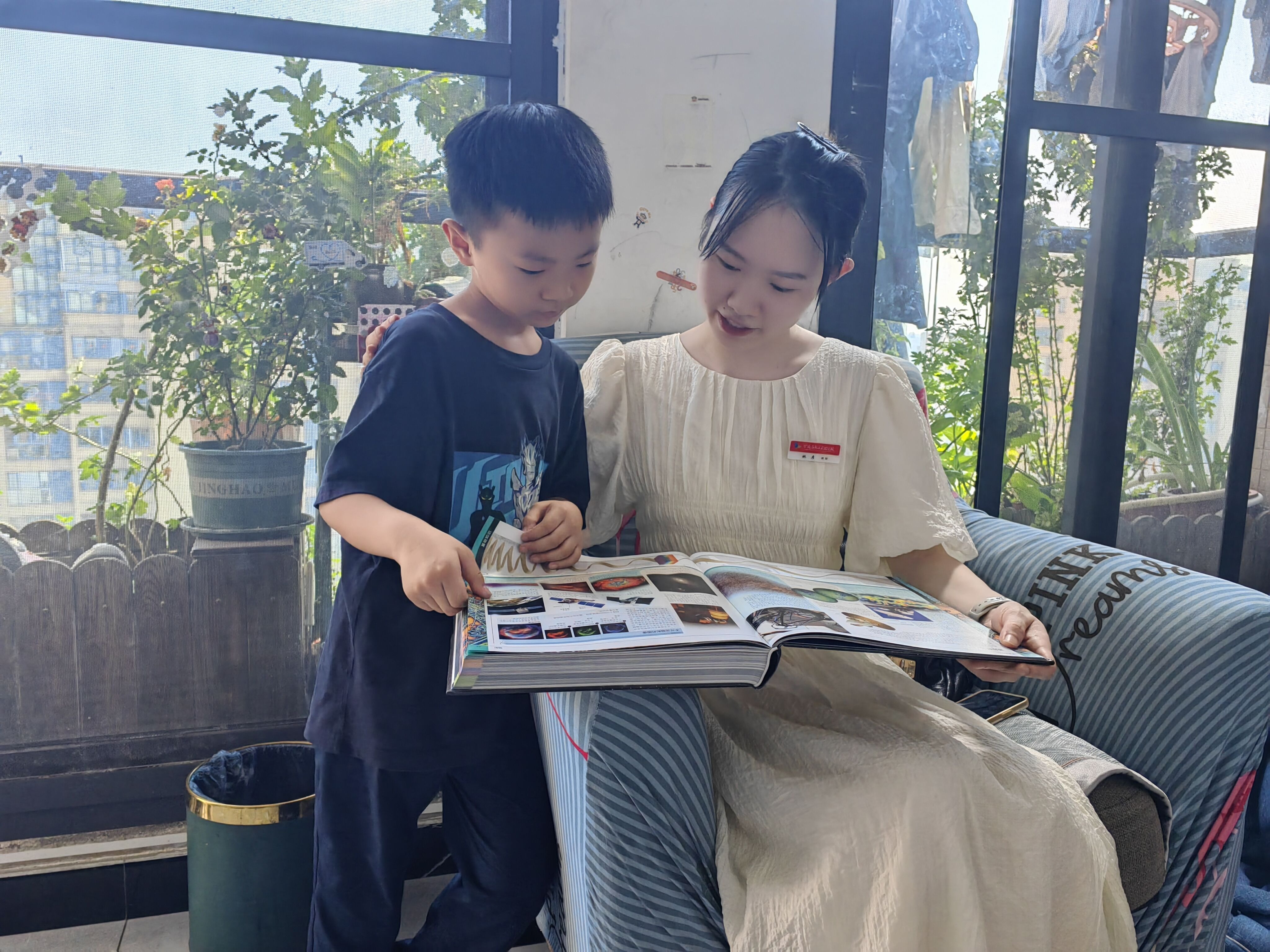 在家访中学生向老师展示正在阅读的《百科全书》学校供图.jpg