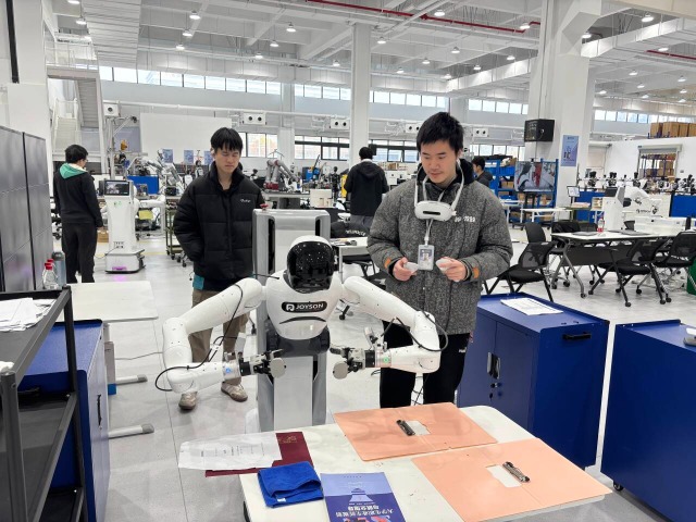 浙江工商职业技术学院“普智未来”订单班学生在调试机器人 学校供图.png